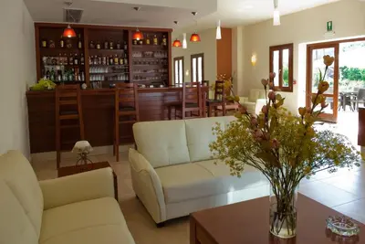 a living room with a white couch and a bar at Syia Hotel in Sougia