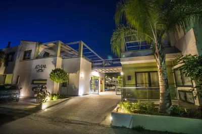 a building with a palm tree in front of it at Athina Beach Hotel in Kato Daratso
