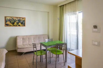 a living room with a table and chairs and a couch at Athina Beach Hotel in Kato Daratso