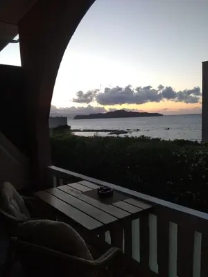 a table on a balcony with a view of the ocean at Villa Georgia Apartments & Suites in Kalamaki Chanion