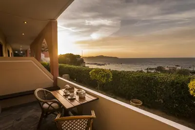 a table and chairs on a balcony with a view of the ocean at Villa Georgia Apartments & Suites in Kalamaki Chanion