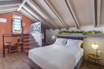 a bedroom with a large bed and a desk at 1924 suites in Chania Town
