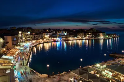 a city at night with lights on the water at 1924 suites in Chania Town