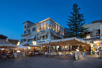a building with tables and umbrellas in front of it at 1924 suites in Chania Town