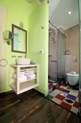 a green bathroom with a sink and a shower at Elia Fatma Boutique Hotel in Chania Town