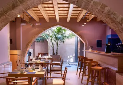 a restaurant with tables and chairs and a palm tree at Elia Fatma Boutique Hotel in Chania Town