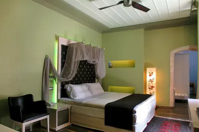 a bedroom with a bed and a black chair at Elia Fatma Boutique Hotel in Chania Town