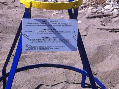 a sign sitting on top of a chair in the sand at Matzi Hotel Apartments in Gerani Chanion