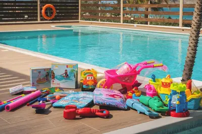 a pile of toys sitting next to a swimming pool at Seaview Garden Villa - Heated Pool & Sauna in Stalos
