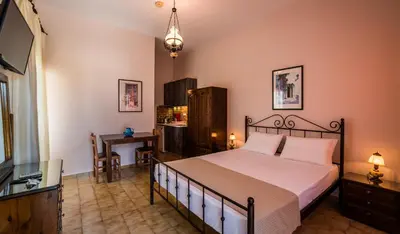 a bedroom with a bed and a desk and a television at Villa Merabello in Agia Marina Nea Kydonias