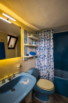a bathroom with a blue toilet and a sink at Kalyves Maisonette Bougainvillea in Kalyves