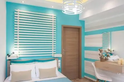 a bedroom with a bed and a blue wall at Kalyves Maisonette Bougainvillea in Kalyves