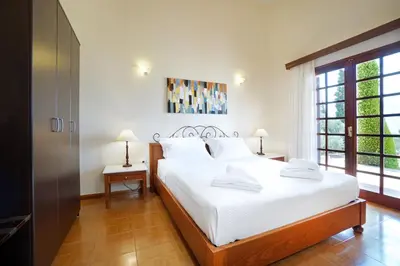 a bedroom with a large white bed and a window at Villa Thealassa - Hanging Over the Sea by etouri in Kounoupidhianá