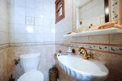 a bathroom with a sink and a toilet at Villa Thealassa - Hanging Over the Sea by etouri in Kounoupidhianá