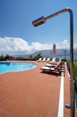 a swimming pool with chairs and a light pole at Villa Thealassa - Hanging Over the Sea by etouri in Kounoupidhianá