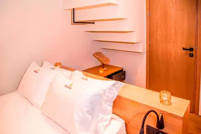 a bedroom with a bed with white pillows and a staircase at Portou House in Chania Town