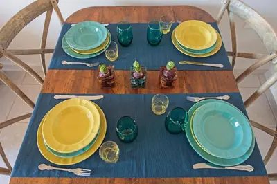 a table with plates and forks and glasses on it at Sody Magnificent Bay View in Chania Town