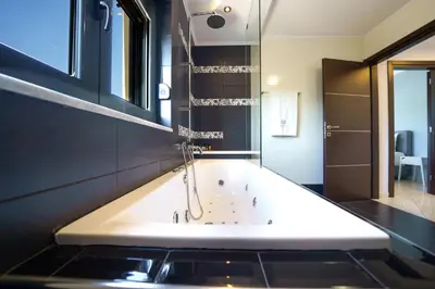 a bath tub in a bathroom with a sink at Mythic Olive villa - Heated Pool - Amazing view in Perivólia
