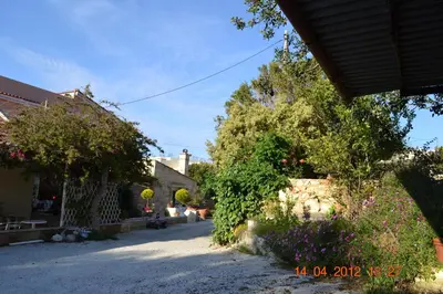a garden with flowers and trees and a building at Rumpis Traditional House in Kambánion
