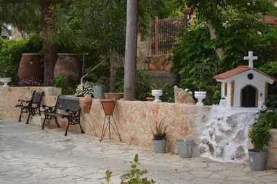a bench and a small chapel next to a wall at Rumpis Traditional House in Kambánion