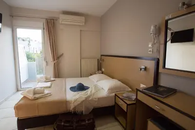 a hotel room with a bed and a television at Theofilos City Hotel in Chania Town