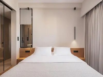 a bedroom with a large white bed and a mirror at Theofilos City Hotel in Chania Town