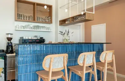 a kitchen with four chairs and a blue counter at Frini Hotel in Chania Town