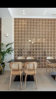 a dining room with a table and chairs and a wall at Frini Hotel in Chania Town