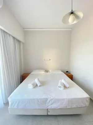 a bedroom with a white bed with two towels on it at Frini Hotel in Chania Town