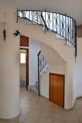 a staircase in a house with a wooden door at Villa Anva in Kato Daratso