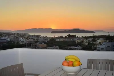 a bowl of fruit sitting on a table with the sunset at Villa Anva in Kato Daratso