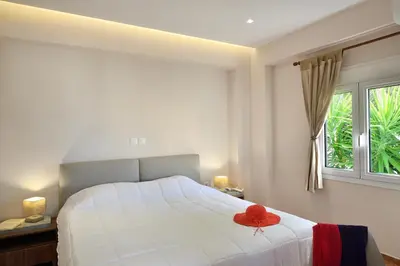 a bedroom with a bed with a red hat on it at Villa Anva in Kato Daratso