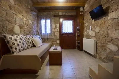 a living room with a couch and a stone wall at Dimitra's House in Old Town in Chania Town