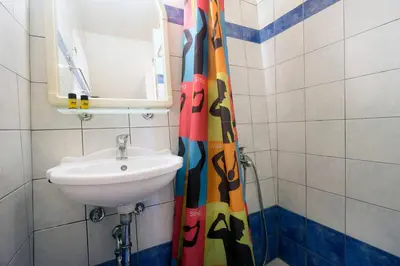 a bathroom with a sink and a shower curtain at Dimitra's House in Old Town in Chania Town