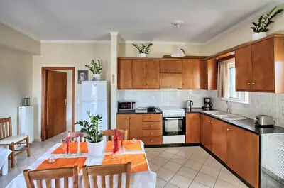 a kitchen with a table with chairs and a refrigerator at Gianna's House in Gerani Chanion