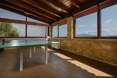 a ping pong table in a room with windows at Villa dimitris in Kissamos