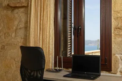 a laptop computer sitting on a desk next to a window at Villa dimitris in Kissamos