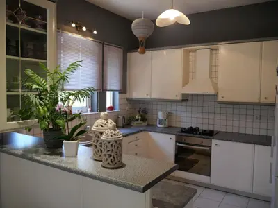 a kitchen with white cabinets and a granite counter top at Rosy's House with all Amenities near Chania in Chania Town