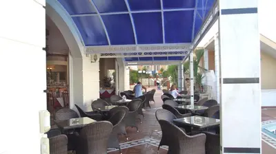 a restaurant with chairs and tables and a blue ceiling at Elektra Beach Hotel in Kalamaki Chanion