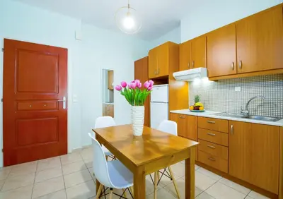 a kitchen with a wooden table with a vase of flowers on it at Downtown Studio Chania in Chania Town