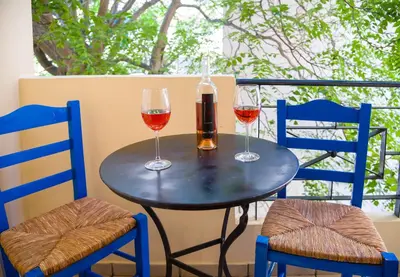 two glasses of wine on a table with two chairs at Downtown Studio Chania in Chania Town