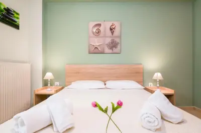 a bedroom with a large white bed with towels on it at Downtown Studio Chania in Chania Town