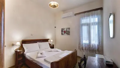 a bedroom with a bed and a desk and a window at Emmanouil’s House in Chania Town
