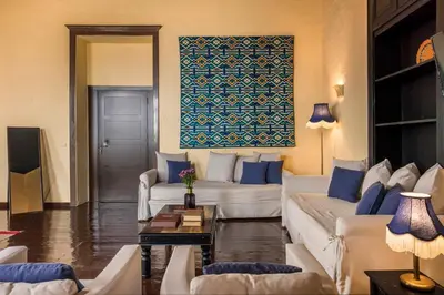 a living room with two white couches and a blue wall at Alcanea Boutique Hotel in Chania Town