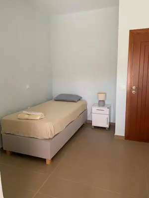 a small bedroom with a bed and a night stand at Stellar Beachhouse in Gerani Chanion