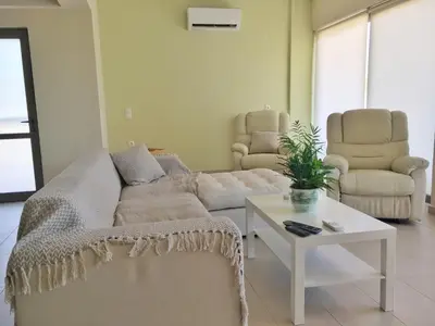 a living room with a couch and a table and chairs at Stellar Beachhouse in Gerani Chanion