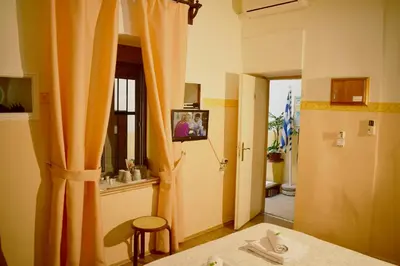 a room with an orange curtain and a television at Stoa Rooms in Chania Town