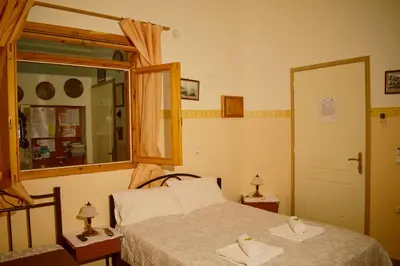 a bedroom with a bed and a window and a mirror at Stoa Rooms in Chania Town