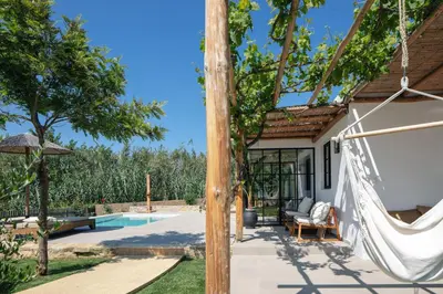 a patio with a hammock next to a house at San Pietro Villa in Plataniás