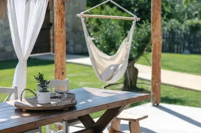 a wooden table with a hammock on a patio at San Pietro Villa in Plataniás